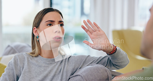 Image of Woman, fight and divorce on sofa in home with discussion, talking or upset with spouse for cheating. Female person, wife and gesture in stop for lies of infidelity, conflict or problem in living room