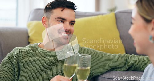 Image of Couple, happy man and champagne for cheers in living room for celebration, anniversary and event. Husband, face and smile with spouse for good news with drink, glass and home for sitting on floor