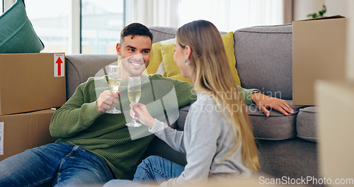 Image of Couple, moving and home celebration with champagne drink at new property living room, boxes or future. Man, woman and wine glass as achievement happy or apartment change or milestone, cheers at sofa