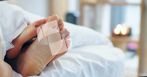 Image of Feet, love and a couple sleeping in bed together for romance or bonding in their home in the morning. Relax, dating or playful with a man and woman barefoot in the bedroom of their apartment closeup
