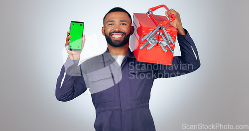 Image of Portrait, handyman and smartphone with green screen, tool box and smile on white studio background. Face, person and model with cellphone, tracking markers and mechanic with mockup space or promotion