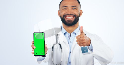 Image of Phone, green screen and portrait of doctor with thumbs up, agreement or registration in white background. Studio, healthcare or sign for like, yes and ok mobile app for telehealth services or success