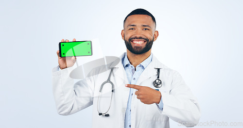 Image of Phone, green screen and portrait of doctor pointing to registration, sign up or info in white background. Studio, healthcare and mobile app for telehealth services, communication or presentation