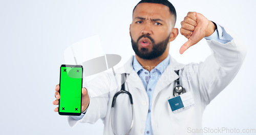 Image of Phone, green screen and portrait of doctor with thumbs down, review or fake news in white background. Studio, healthcare or sign for negative, feedback and dislike mobile app for telehealth services