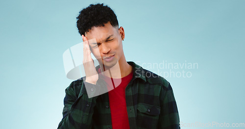 Image of Tired, studio or man with headache, burnout or fatigue in crisis with head pain or emergency. Depression problem, face or person frustrated by ptsd, migraine or stress isolated on blue background