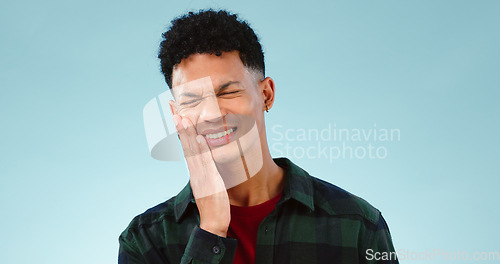 Image of Man, toothache or pain in studio with gum problem, cavity or dental crisis by blue background. Model, face and hands by teeth care for tmj, gingivitis and oral decay or orthodontics help in mockup