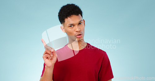 Image of Portrait, pointing or man with promotion, announcement and information with review on blue background. Face, person or model with sale, hand gesture or mockup space with opportunity, show or feedback