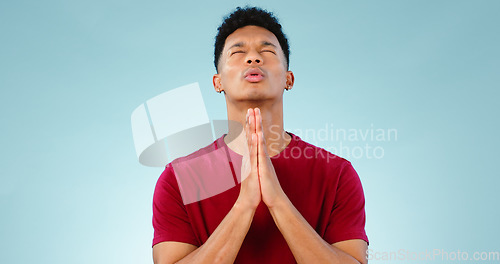 Image of Religion, praying and young man in a studio for hope, gratitude and spiritual expression. Prayer, christian and male person from Mexico speaking for worship to god isolated by blue background.