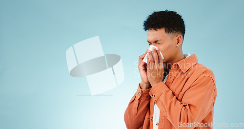 Image of Man, blowing and nose for sinus in studio for healthcare mock up on blue background in Cape Town. Male model, hand and tissue for hay fever, flu or congestion for allergies with announcement in space