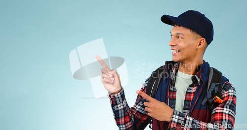 Image of Happy, backpack and man in studio pointing for choice, decision and option on blue background. Travel, tourist mockup and isolated excited person with hand gesture for hiking, adventure and vacation