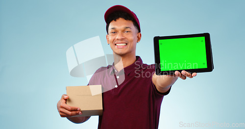 Image of Delivery person, tablet and green screen in studio for smile, mockup space and box by blue background. Courier man, cardboard package and portrait for app promotion, chromakey and tracking markers