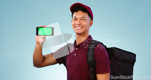 Image of Delivery man, phone and green screen in studio with smile, mockup space and bag by blue background. Supply chain portrait, backpack and smartphone for app promotion, ecommerce and tracking markers