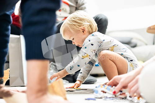 Image of Parents playing games with child. Little toddler doing puzzle. Infant baby boy learns to solve problems and develops cognitive skills. Child development concept