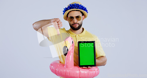 Image of Green screen, tablet and man with thumbs down in studio for travel agency, review or service feedback on grey background. Digital, space and sad male traveler with emoji vote for app disappointment