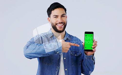 Image of Man, smartphone or pointing to green screen in portrait, mockup space or happy for advertising. Arab person, smile or face in marketing of tracking markers, mobile app or contact by white background