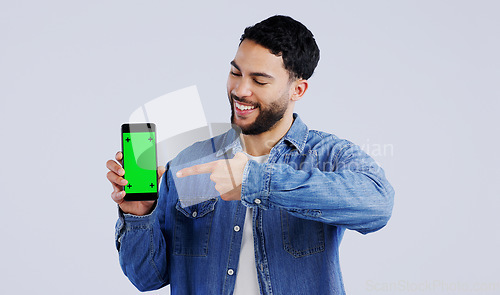 Image of Man, cellphone or pointing to green screen in portrait, mockup space or happy for advertising. Arab person, smile or face in marketing of tracking markers, mobile app or contact by white background