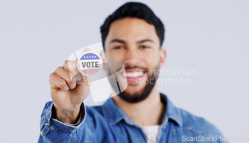 Image of Vote, smile and portrait of man with badge in studio for choice, decision or registration on grey background. Government, politics and face of happy voter with support, freedom and party election