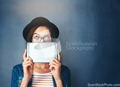 Image of Face, tablet screen and mockup with a fashion woman in studio on a blue background for social media marketing. Thinking, display and style with a young person holding empty tech for advertising space