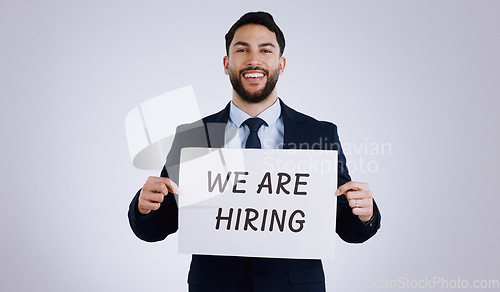 Image of Happy businessman, portrait and hiring sign for opportunity, advertising or marketing against a gray studio background. Man smile with billboard or poster for recruiting, interview or career position