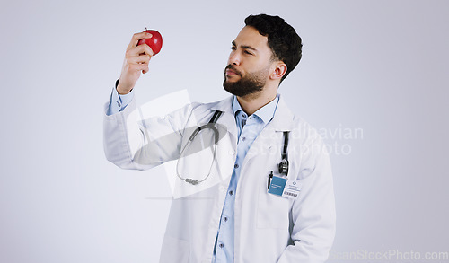 Image of Healthcare, doctor and thinking with apple in studio for mockup in nutrition on white background. Mexican person, male model or medical professional by red fruit in vegan, vegetarian or diet in space
