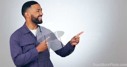 Image of Happy man, pointing and mockup space for advertising or marketing against a studio background. Male person or salesman smile showing deal, list or information for advertisement, notification or alert