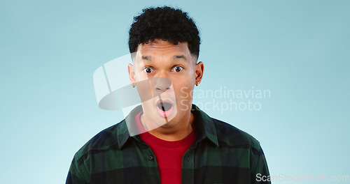 Image of Wow, man and portrait in studio with shocked face for announcement, discount or good news on mock up space. Person, surprised or emoji for secret, gossip or surprise with big eyes on blue background
