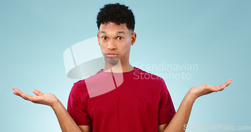 Image of Portrait, man and shrug for doubt in studio for promotion with mock up for option, decision or choice. Male model, face and unsure or confused with presentation, scale or deal on blue background