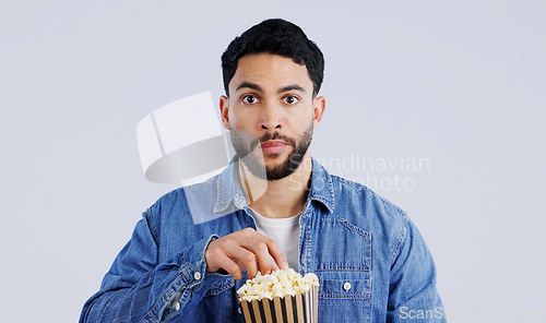 Image of Television, portrait and man with popcorn in studio for movie, film or documentary on grey background. Cinema, watching tv and face of model with theater snack for video, entertainment or streaming