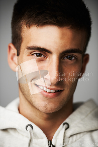 Image of Portrait, smile and man in hoodie for fashion isolated on gray studio background. Happy person, face of young model and style or trendy clothes, casual or cool facial expression in Spain on backdrop