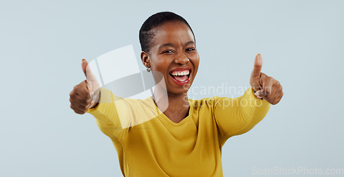 Image of Happy black woman, portrait and thumbs up in winning or good job against a gray studio background. African female person smile with like emoji, yes sign or OK in thank you for approval or success