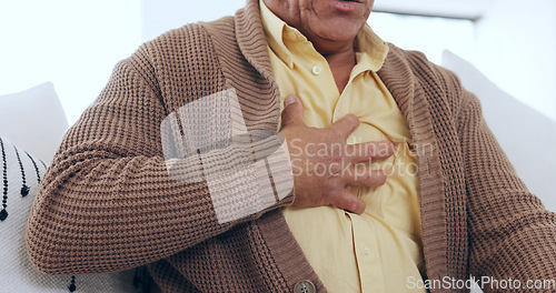 Image of Closeup, home and old man with heart attack, hands on his chest and heartburn in a lounge. Elderly person, pensioner and senior guy with emergency, wellness and issue with asthma or tuberculosis