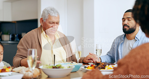 Image of Food, thanksgiving and a family praying at the dinner table of their home together for eating a celebration meal. Love, holidays and a group of people saying grace for health, diet or nutrition