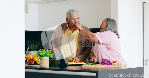 Image of Senior couple, cooking and taste in a kitchen with tablet for recipe, research or online tutorial at home. Love, food and old people with digital app for nutrition, blog or vegetables for meal prep