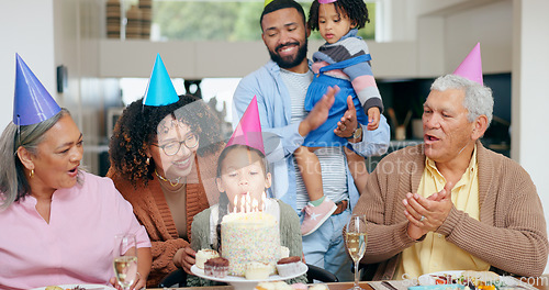 Image of Birthday cake, family and child blow candles with grandparents for celebration, party and singing or clapping. Happy interracial people, mother and father with girl kids for special holiday at home