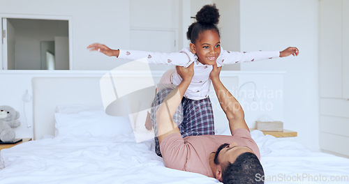 Image of Father, daughter and airplane on bed with playing, bonding and freedom for happiness or trust in bedroom of home. Family, man and girl child with lifting in knees with balance, relationship and love