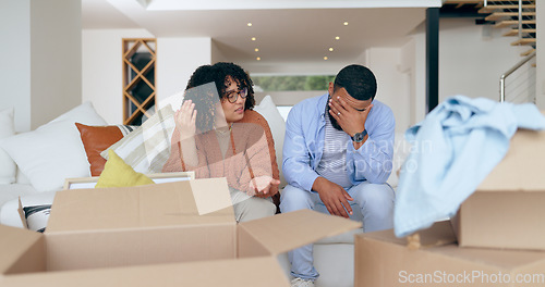 Image of New home, box and frustrated couple on sofa for house, property investment and moving day. Conflict, argue and man and woman with crisis, problem and fight for mortgage, rent and real estate purchase