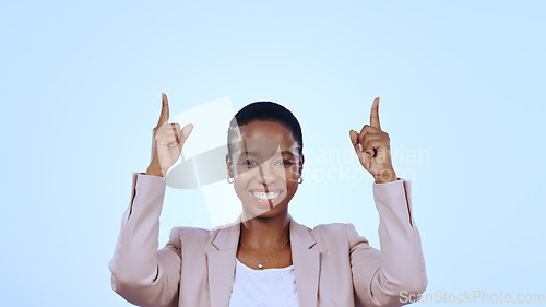 Image of Portrait, happy black woman or pointing up to offer, announcement or advertising news. Studio, blue background or business person isolated to show marketing of promotion, sale or commercial review