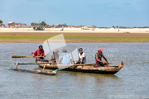 Image of Malagasy family in traditional wooden boat crossing River in Morondava, Madagascar.