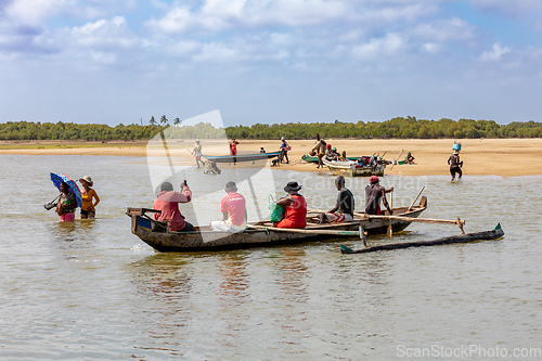 Image of Malagasy family in traditional wooden boat crossing River in Morondava, Madagascar.