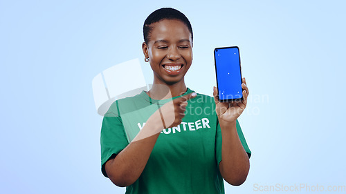 Image of Woman, volunteer and phone green screen, presentation mockup and support, join us or marketing in studio. Happy African person pointing to mobile, information and NGO volunteering on blue background