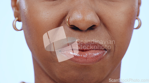 Image of Woman, face and closeup of nose and mouth in studio with disgust for bad smell, dislike scent or air. Person, negative facial expression or reaction to sweat, nausea or aroma on blue background