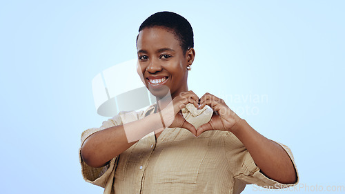 Image of Heart, hands and portrait of black woman in studio for kindness, care and charity donation on blue background. Happy model show sign of love, hope and thank you for support, emoji and review of peace