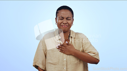 Image of Black woman, chest and sore throat in heart burn or cough isolated against a studio blue background. Sick African female person or model with respiratory infection, disease or inflammation on mockup