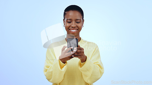 Image of Happy woman, smile or texting on mobile app in studio for mockup of social media on blue background. Black person, face and looking at screen for email, message or reading on internet, online or web