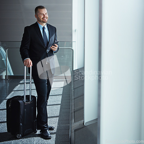 Image of Business man, phone and bag in airport hallway for smile, thinking and vision by window for international travel. Entrepreneur, luggage and smartphone with flight schedule for immigration in London