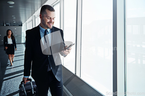 Image of Business man, phone and travel in airport window for reading, thinking and contact in corridor with smile. Entrepreneur, luggage and smartphone for flight schedule and global immigration in London
