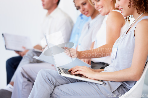 Image of Waiting room, laptop and business people for recruitment information, job search or human resources opportunity. Professional woman in chair typing on computer, resume update or CV for online hiring