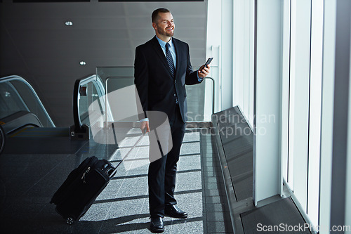 Image of Happy, thinking or business man in airport with phone, luggage or suitcase waiting to travel. Smile, male entrepreneur or corporate worker texting on social media mobile app on international flight