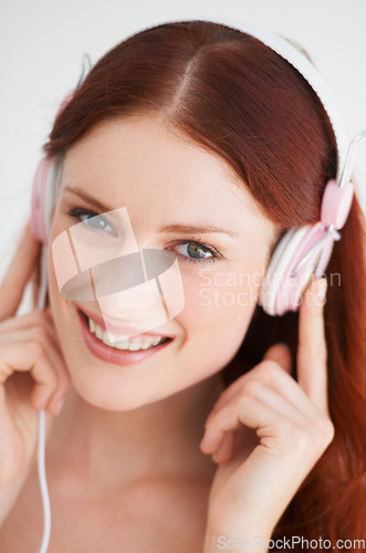 Image of Smile, headphones and portrait of woman in a studio listening to music, playlist or album. Happy, excited and young female model from Canada streaming a song or radio isolated by white background.