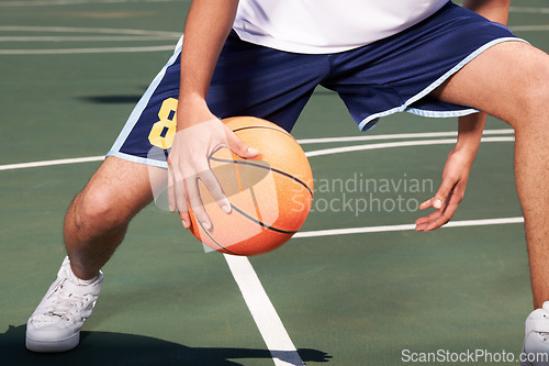 Image of Man, legs and basketball on court for playing, training or workout with performance and wellness. Athlete, person or ball for sport, exercise or technique with fitness, skill and sports match outdoor